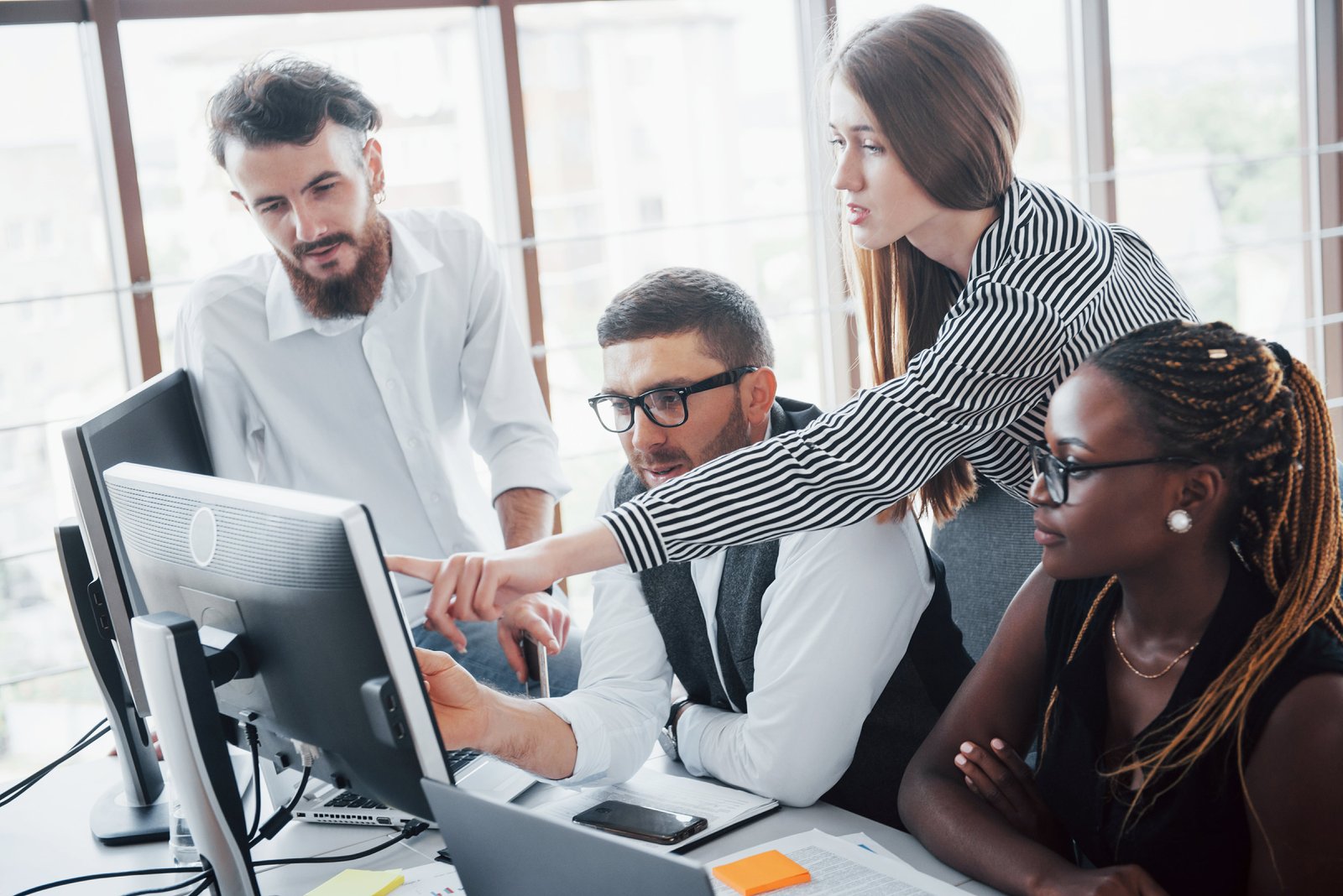 young-employees-sitting-office-table-using-laptop-min